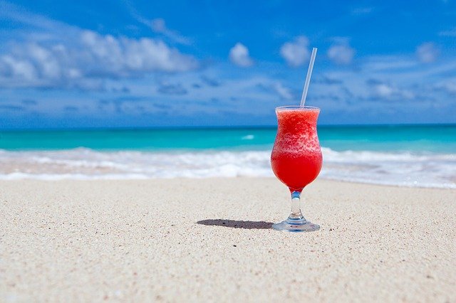 pohár s drinkom na pláži